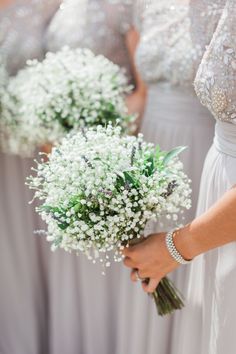 the bridesmaids are holding bouquets of baby's breath in their hands