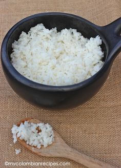 rice in a black bowl and wooden spoon