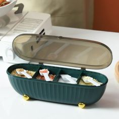 an open lunch box sitting on top of a table next to a bowl of food