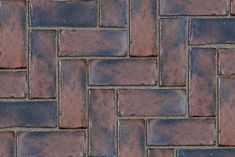 a close up view of a brick floor with dark brown and red bricks on it