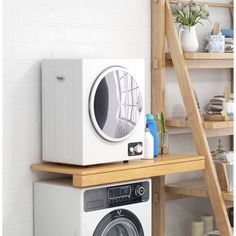 a washing machine sitting on top of a shelf next to a dryer