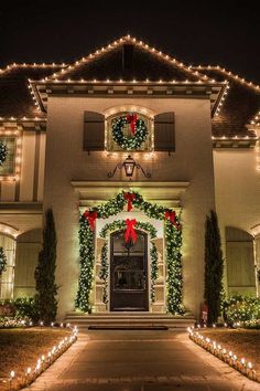 a house with christmas lights and wreaths on the front