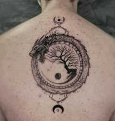 a man with a tree and moon tattoo on his back