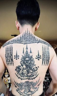 the back of a man with tattoos on his body