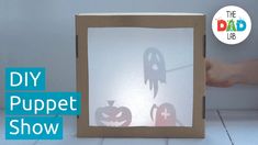 a cardboard box with cut out ghost and pumpkins on the inside that says diy puppet show