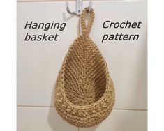 a crochet basket hanging on the wall next to a hook with two hooks