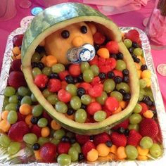 a watermelon shaped like a bear surrounded by grapes, strawberries and melons