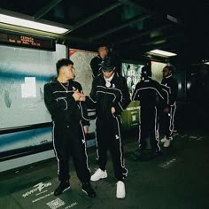 men in black and white tracksuits waiting for the subway