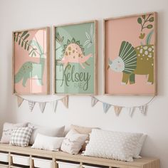 three framed pictures hang on the wall above a bench with pillows and pillow cases underneath them