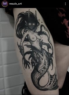 a black and white photo of a mermaid tattoo