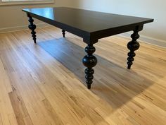 a black table sitting on top of a hard wood floor next to an open window