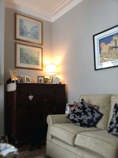 a living room filled with furniture and pictures on the wall