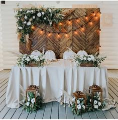 the table is set up with white flowers and greenery