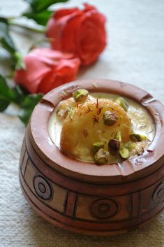 there is a small wooden box with food in it next to some flowers on the floor