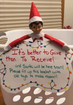 an elf is sitting on top of a basket with a sign that says it's better to give than to receive