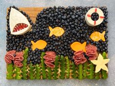 a wooden board topped with fruit and veggies on top of blue countertop