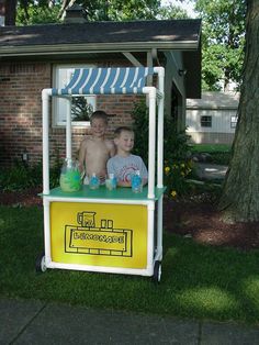 two young boys are sitting in an ice cream cart