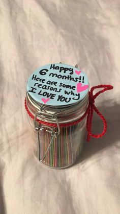 there is a small jar with writing on it and a red string around the lid