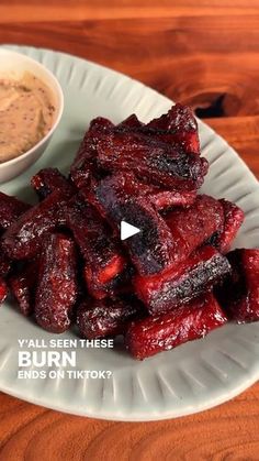 beets on a plate next to a small bowl of dip and some sort of sauce