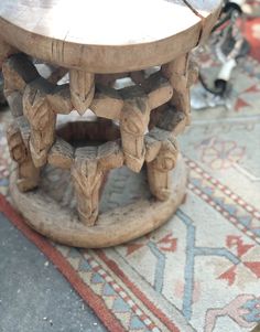 an old wooden stool sitting on top of a rug