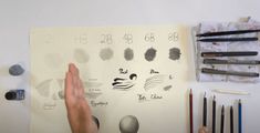 a person pointing at some drawings on a piece of paper