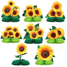 sunflowers are arranged in green vases with leaves