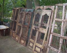 an old wooden gate with metal bars on the top and bottom, in front of a bathtub