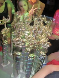 two girls are looking at trophies on a table