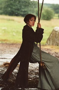 a woman sitting on a swing in the rain