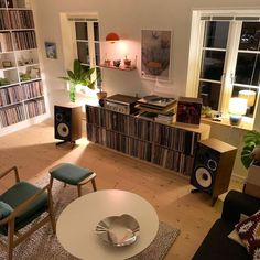 a living room filled with furniture and bookshelves next to a large white table