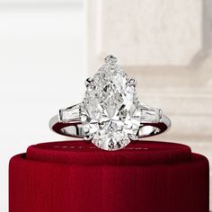 a diamond ring sitting on top of a red box