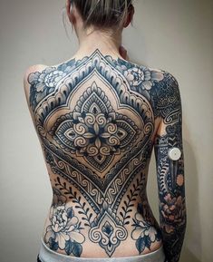 the back of a woman's body with tattoos on her upper and lower half