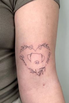 a woman with a tattoo on her arm has a heart shaped pig in the center