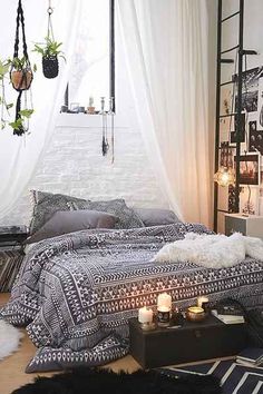 a bedroom with black and white bedding, rugs and hanging plants on the wall