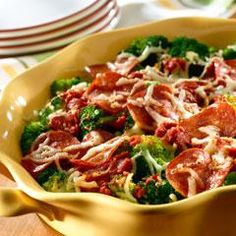 a yellow bowl filled with broccoli and meat