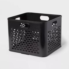 a black plastic basket with holes on the front and sides, sitting on a white surface