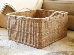 a wicker basket sitting on the floor next to a couch