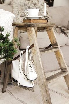 an old wooden step ladder with white shoes on it and a cup next to it