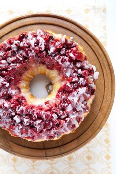 a cake covered in cranberry sauce on top of a wooden plate