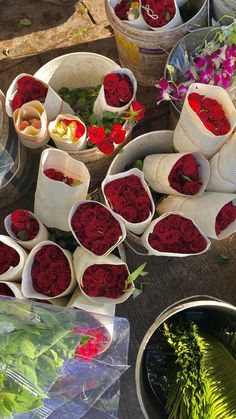 many different types of flowers in buckets on a table