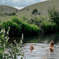 two people are swimming in the river together