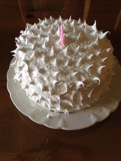 a cake with white frosting and a pink candle