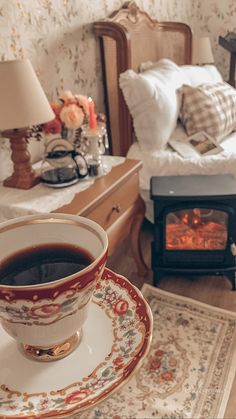 a cup of coffee sitting on top of a saucer next to a fire place