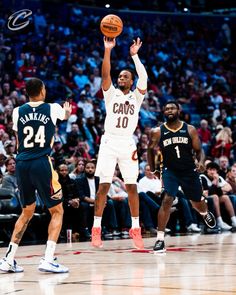 the basketball player is trying to block the ball from being blocked by two other players