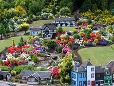 an aerial view of a model town with lots of flowers and houses on the ground