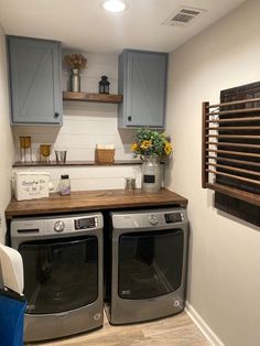 a washer and dryer in a small room with wooden counter tops on the floor