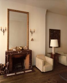 a living room filled with furniture and a large mirror on the wall over a fire place