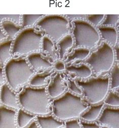 an image of a white lace with flowers on it and the words pic 2 written below