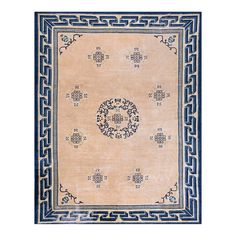 a beige rug with blue border and an intricate design on the center, in front of a white background