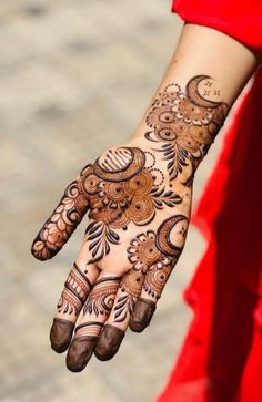 a woman's hand with henna tattoos on it